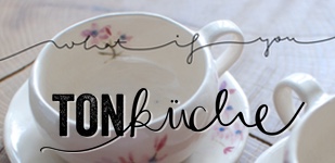 Eine Tasse aus der Ton-Küche mit zarten, handgemalten, aquarellartigen Blumen